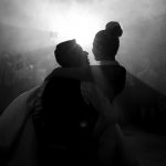 Fotografía de boda durante el baile nupcial. Contraluz nocturno aprovechando los reflejos del humo artificial.